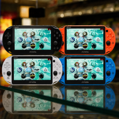 Four PS Vita Slim consoles in Black, Neon Orange, Glacier White, and Aqua Blue