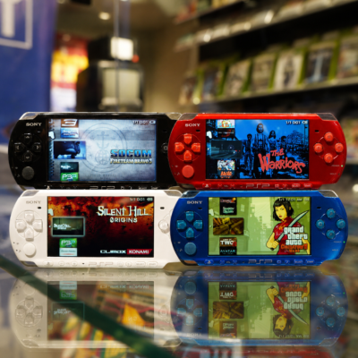 Four PSP 3000 consoles in Piano Black, Radiant Red, Pearl White, and Vibrant Blue